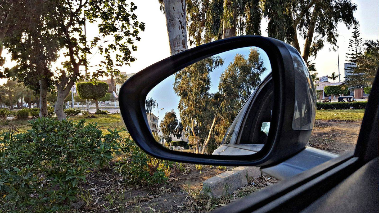 Vue depuis l’habitacle d’une voiture à travers une vitre latérale, rétroviseur extérieur au premier plan : simulateur de vitres teintées We Dryv Group à Frontignan, près de Sète